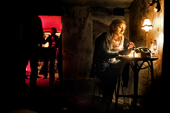 Liebe zur Dekoration: Maren Reinacher sitzt während einer Veranstaltung an einem Tisch, auf dem ein Telefon mit Wählscheibe neben einer alten Lampe steht.